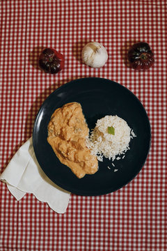 vertical photography of strogonoff chiken with tomatoes and garlic