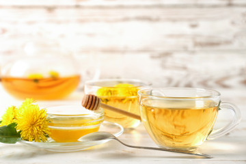 Healthy dandelion tea with honey on white wooden background