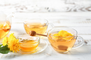 Healthy dandelion tea and honey on white wooden background