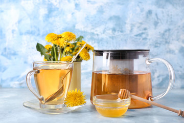 Healthy dandelion tea with honey on color background