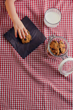 little girl's hand stealing a cookie seen from above