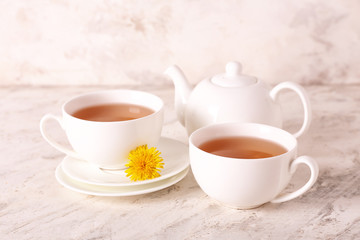 Fototapeta na wymiar Cups of healthy dandelion tea on light background