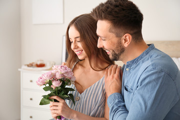 Young woman with received bouquet of flowers from her boyfriend at home