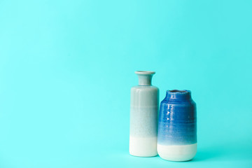 Different vases on color background