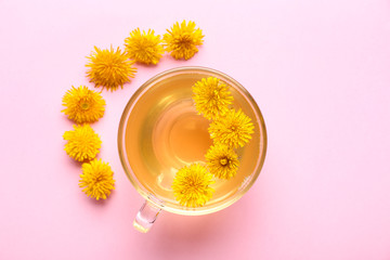 Cup of healthy dandelion tea on color background