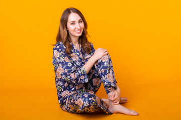 Obraz premium Fashion portrait pretty cool girl having fun over colorful yellow background. Pajama and home clothes concept
