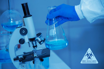 Fototapeta premium Close up of scientist hand holding scientific glassware ,LAB scientific and chemistry background of Covid-19 blood test tube and microscope