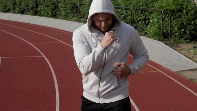 Bodybuilder exercising on the fresh air on a stadium in the sunset