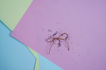 tied gold ribbon with glitters on colourful papers