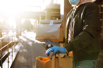 Courier delivering  paper packet  with food and coffe on a scooter in quarantine city. Delivery service concept. Covid-2019.