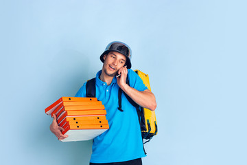 Calling to client. Emotions of caucasian deliveryman isolated on blue background. Contacless delivery service during quarantine. Man delivers food during isolation. Safety. Hurrying up. Looks fun.