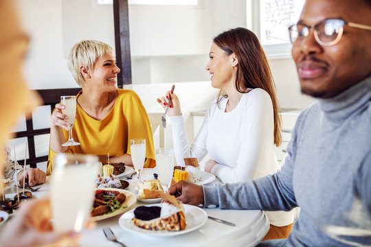 Top view of five multicultural friends sitting at dinning table and having healthy lunch.