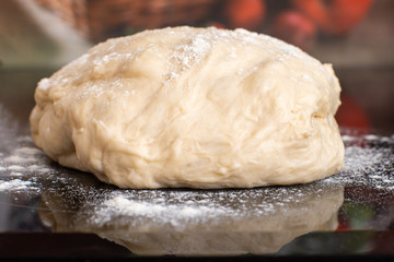 Close-up of dough and flour in the kitchen. Preparation for pies and rolls. Homemade cakes, cooking. Side view