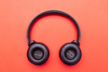 Black headphones. From above . Red background. Copy space
