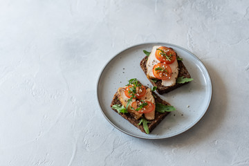 A grilled organic chicken sandwich on a napkin with an apple