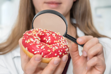 Scientist examines a donut with magnifying glass