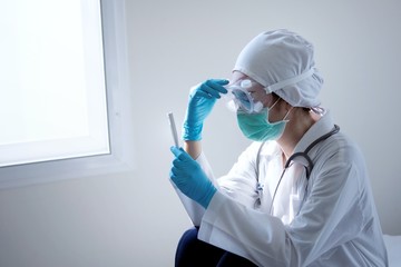 Fototapeta premium Close up of female asian doctor is infected with a virus has stress in Coronavirus outbreak or Covid-19, in wearing protective shuit, Green mask,face shield and blue gloves 