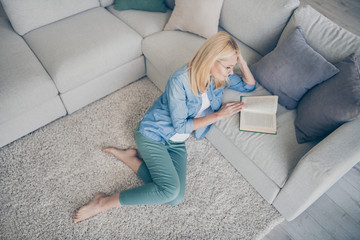 High angle above view photo of attractive aged homey lady sitting comfy fluffy carpet near couch...