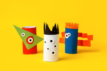 Obraz premium Kids art therapy, coronavirus pandemic. Halloween crafts, paper monsters on blue paper background with copy space for text. Concept handcraft, diy, creative idea from toilet tube, recycle