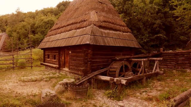 Old wooden shack house in a village. Cabin with straw roof. Peasant house in historical museum.