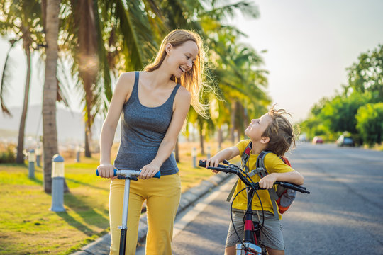 Active School Kid Boy And His Mom Riding A Bike With Backpack On Sunny Day. Happy Child Biking On Way To School. Safe Way For Kids Outdoors To School