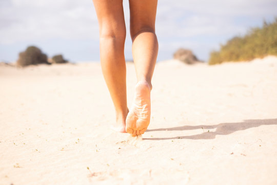Close up of sexy nude young beautiful woman legs walking on the soft sand at the beach in summer holiday free vacation - concept of tourist people enjoy the travel lifestyle in the nature