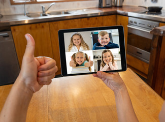 Screen tablet image of school children learning online lesson listening to teacher