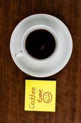 White coffee cup and coffee beans on a wooden table.Coffee time