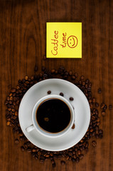 White coffee cup and coffee beans on a wooden table.Coffee time