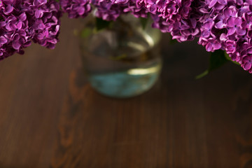 Bouquet of purple lilac on wooden table