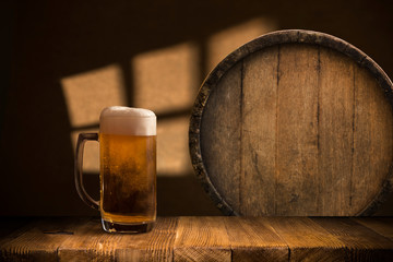 Beer barrel with beer glasses on a wooden table. The dark brown background.