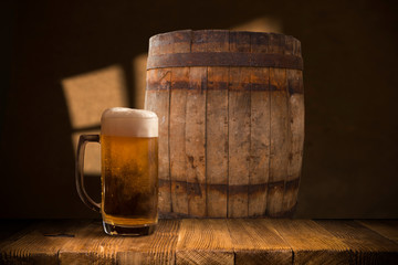 Beer barrel with beer glasses on a wooden table. The dark brown background.