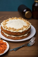 Carrot cake, hazel nuts and grated carrot on the wooden table