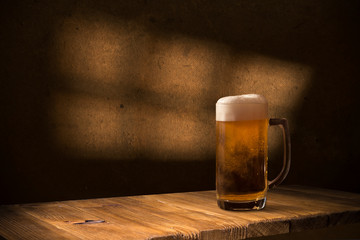 Beer barrel with beer glasses on a wooden table. The dark brown background.