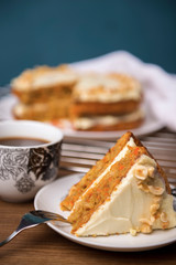 Piece of carrot cake with carrot cake on the background