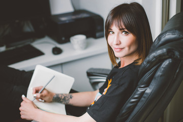 Young woman study and taking notes in notebook in her home office. Remote worker. Work from home. Education online.