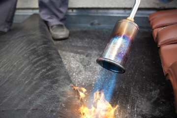 Propane torch heating up bitumen roofing felt