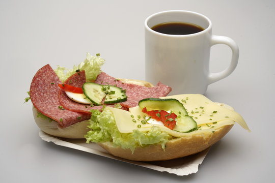 Zwei halbe Belegte Br&ouml;tchen mit Salami und K&auml;se, Tasse Kaffee