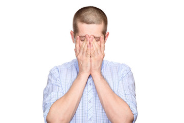 tired distressed man in a classic blue shirt, short haircut; closed his eyes with his hands, from a...