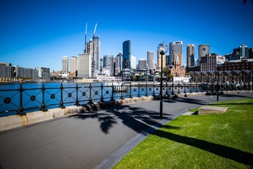 Obraz premium Long exposure Sydney Harbour Australia on a sunny clear blue sky day with the turquoise colours of the bay and high rise offices of the City in the background