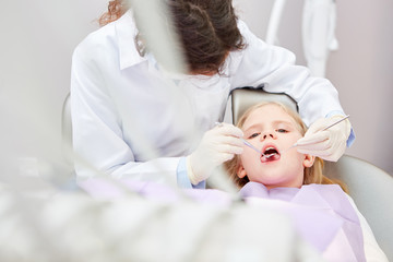 Fototapeta na wymiar Zahnärztin bei Behandlung von kleinem Mädchen