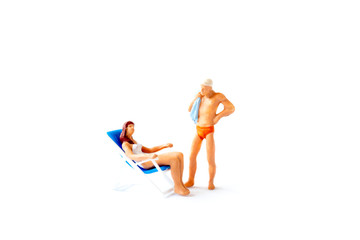 Fototapeta na wymiar Miniature people sunbathing on deck chairs on white background , Summer time concept