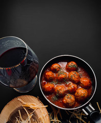 Meatballs with tomato sauce and a glass of wine