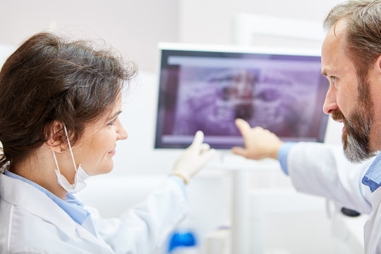 Zahnärzte besprechen Befund auf einem Röntgenbild