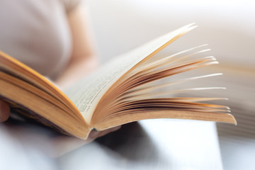 Vintage close up of an old open book with yellow pages. Avid reader, bookworm concept