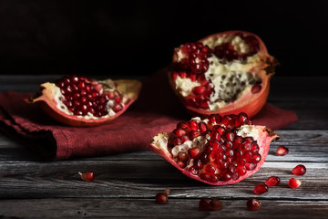 Fresh ripe pomegranate on a dark rustic wooden table. Selective focus.