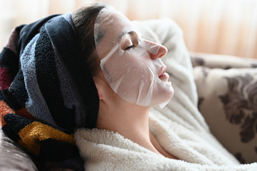 Obraz na płótnie Canvas girl at home moisturizes the skin of the face
