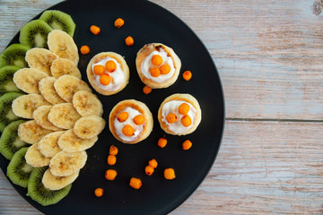 Cheesecakes with sour cream sauce, bananas and sea buckthorn berries