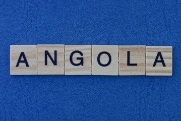  name of the country of angola from the word from gray wooden letters on a blue table