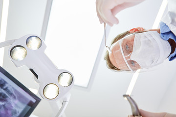 Kieferchirurg mit Visier und Mundschutz